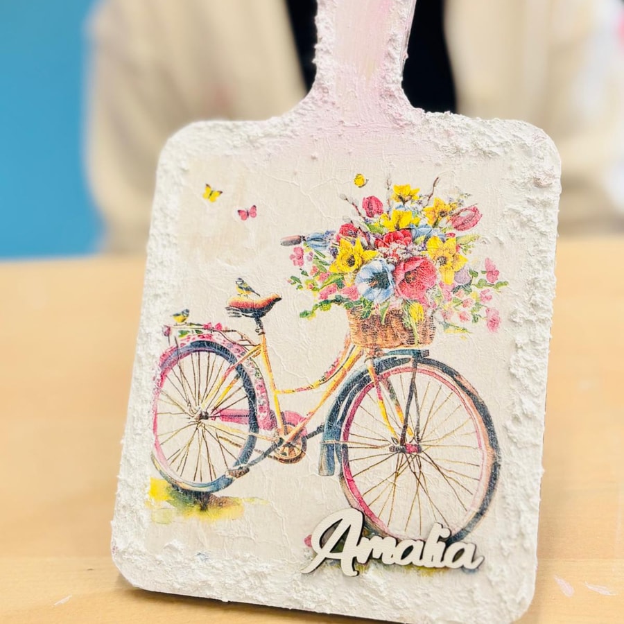 Copii care desenează cu creioane colorate la o masă de activități luminoasă.