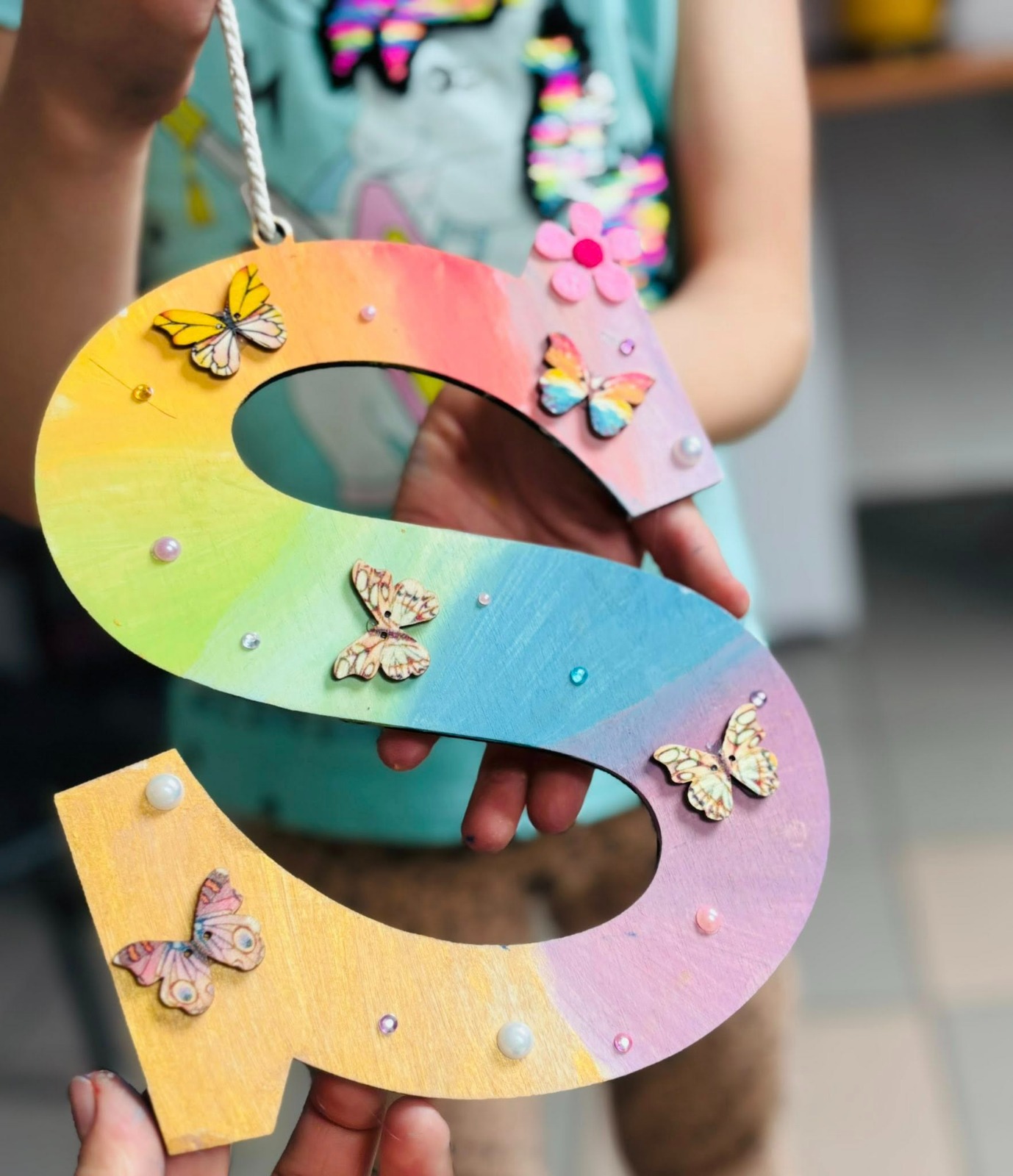 Cadru apropiat: mâna unui copil care colorează pe hârtie.