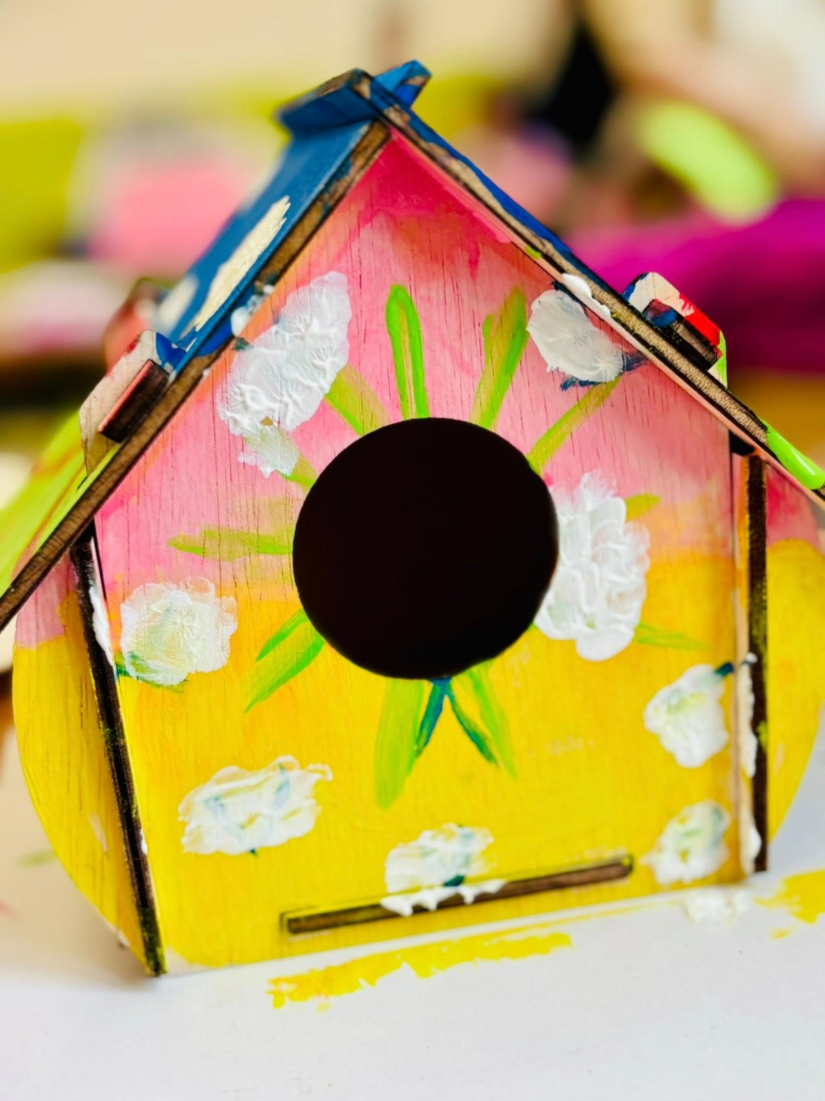 Copii care ascultă un adult care citește într-un spațiu primitor și luminos.