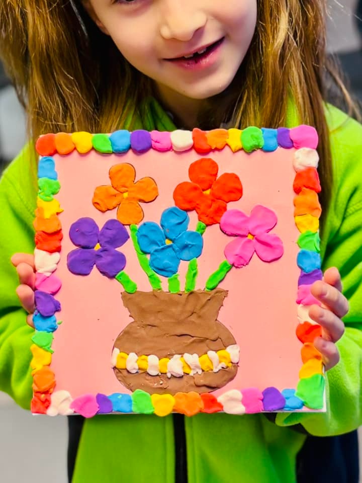 Copil mic cu jucării din fetru, forme din lemn și cărți ilustrate.